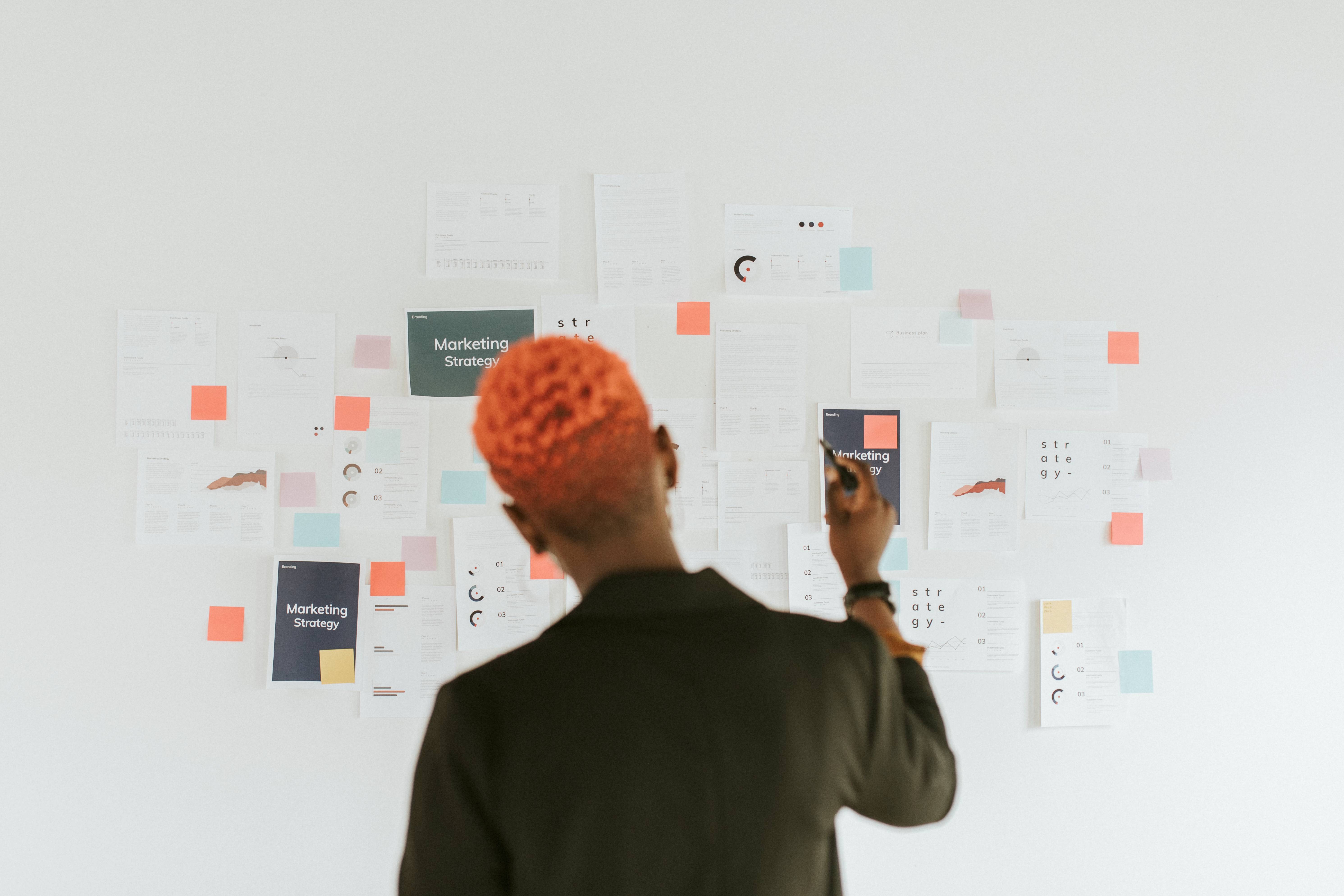 Mujer UX/UI resolviendo retos de la empresa plasmando soluciones en una pizarra